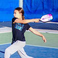 Girl playing pickleball on court